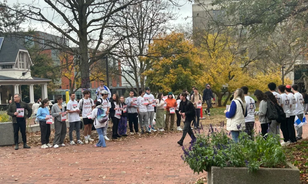 Students gather on a campus walkway holding "KIDNAPPED" posters during a demonstration at the University of Guelph cannon.