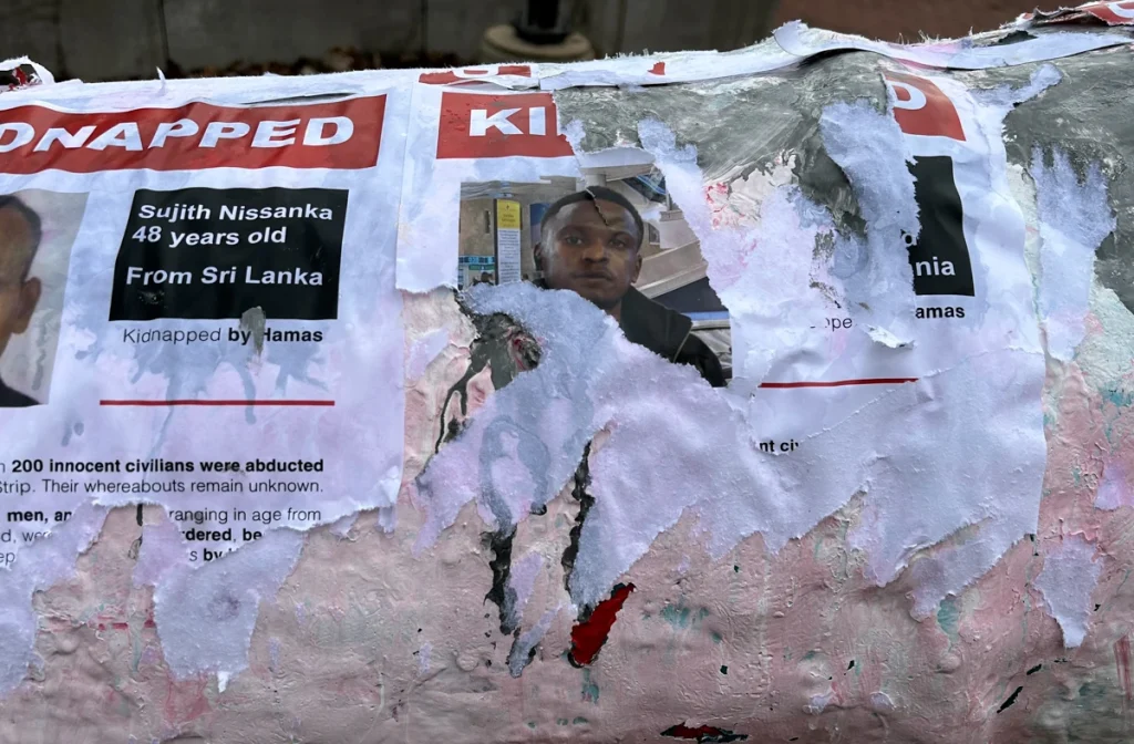 Torn “KIDNAPPED” posters with photos and text pasted onto the University of Guelph cannon statue.