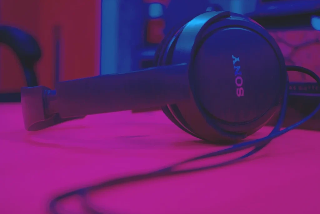 Open notebook decorated with collaged stickers, drawings, and a ticket stub on a desk.